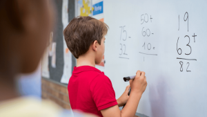 Niño en clase haciendo operaciones matemáticas